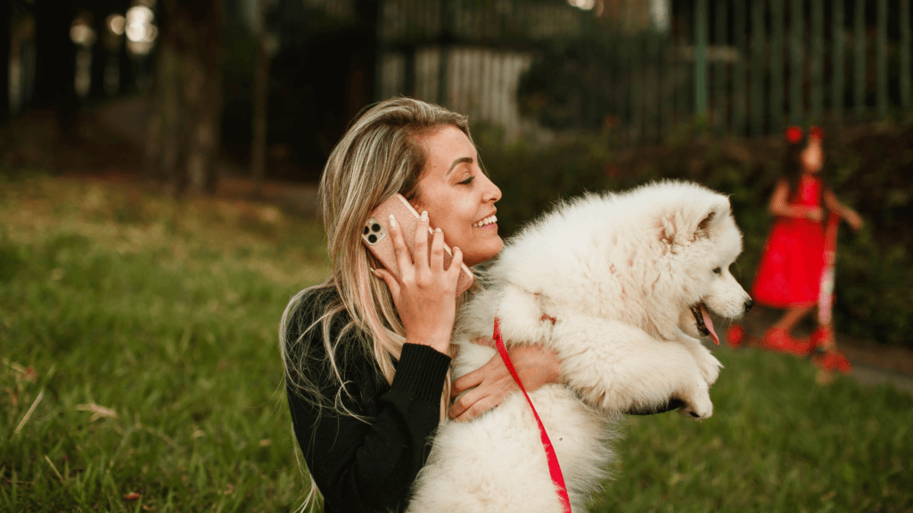 jeune femme qui récupère son chien dans les bras